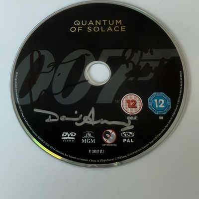 Quantum of Solace DVD disc, signed by Judi Dench, David Arnold and one other. Disc only